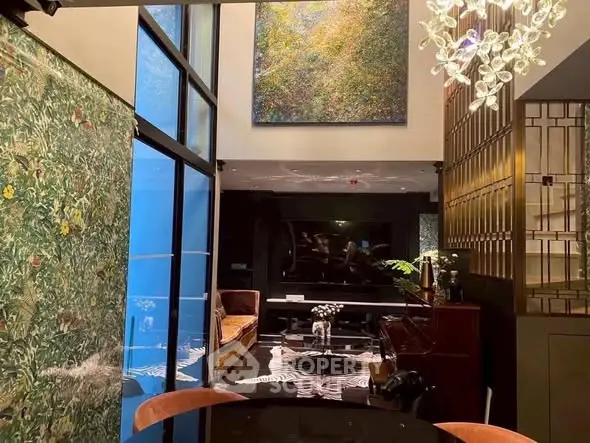 Luxurious living room with high ceilings, modern decor, and large artwork, perfect for sophisticated living.