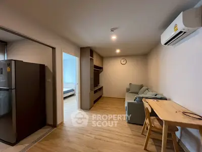 Modern living room with wooden flooring, cozy sofa, and air conditioning in a stylish apartment.