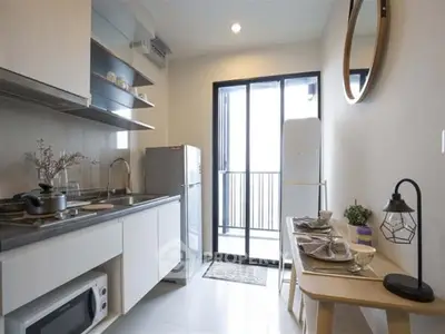 Modern kitchen with sleek design, featuring open layout and balcony access for natural light.