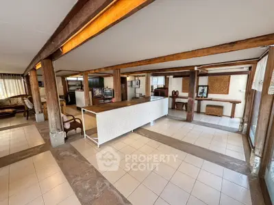 Spacious open-plan living area with rustic wooden beams and modern decor.