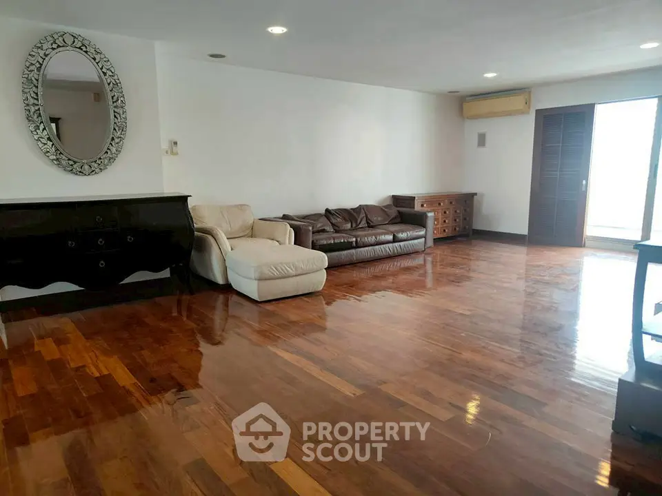 Spacious living room with polished wooden floors and elegant furniture