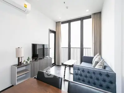 Modern living room with balcony view, stylish furniture, and natural light.