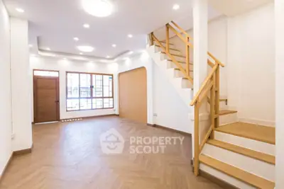 Spacious modern living room with wooden staircase and elegant lighting