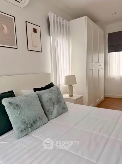 Cozy bedroom with stylish decor and ample natural light