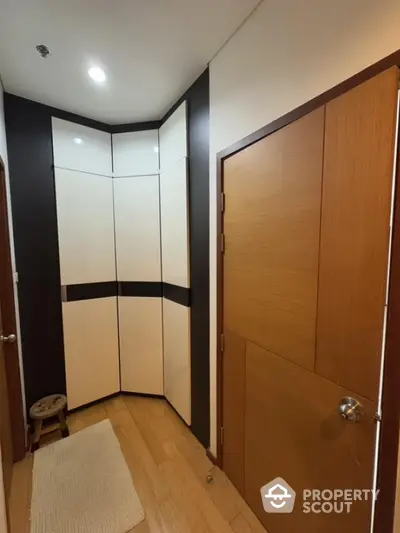 Modern hallway with sleek storage cabinets and wooden doors