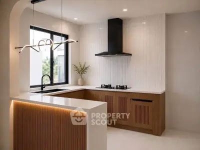 Modern kitchen with sleek design, featuring gas stove and elegant lighting in a stylish open layout.