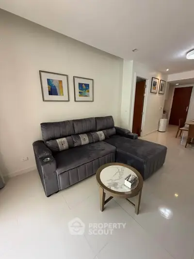 Modern living room with plush gray sofa and stylish decor in a contemporary apartment.