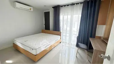 Modern bedroom with large window, sleek furniture, and air conditioning unit.