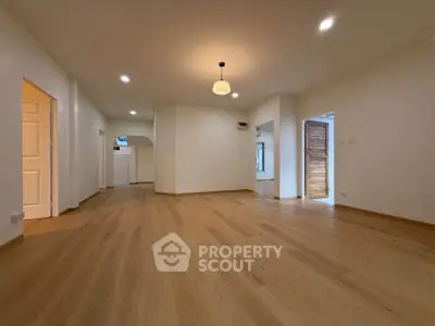 Spacious open-plan living area with elegant wooden flooring and modern lighting.