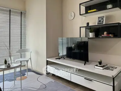 Modern living room with sleek furniture and natural light, featuring a stylish TV setup and contemporary decor.
