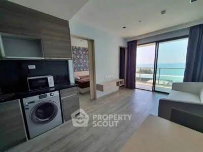 Modern apartment with ocean view, featuring open layout and balcony access.