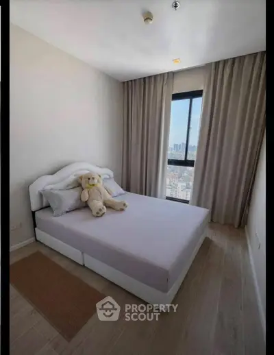 Cozy bedroom with city view, featuring a plush bed and elegant curtains, perfect for relaxation.