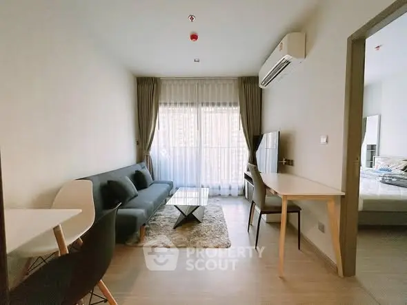 Modern living room with sleek furniture and large window, perfect for urban living.