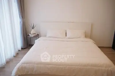 Cozy bedroom with soft lighting and elegant decor, featuring a comfortable bed and stylish side table.