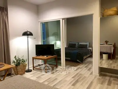 Stylish modern apartment with cozy living room and bedroom, featuring elegant decor and natural lighting.