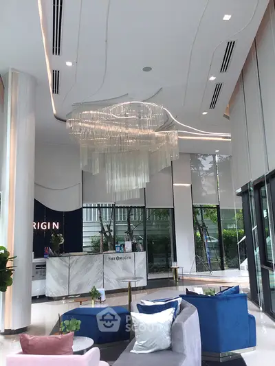 Luxurious modern lobby with elegant chandelier and stylish seating area.