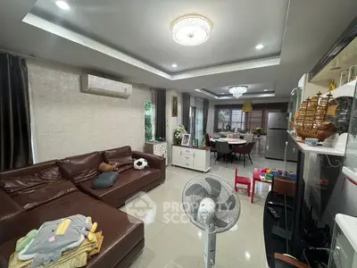 Spacious living room with modern decor and open layout leading to dining area.