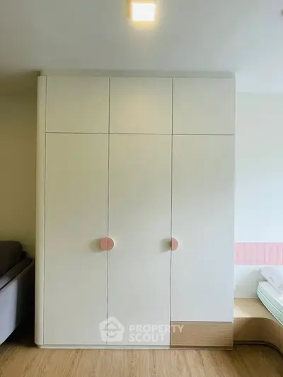 Modern bedroom with sleek wardrobe and cozy bed setup