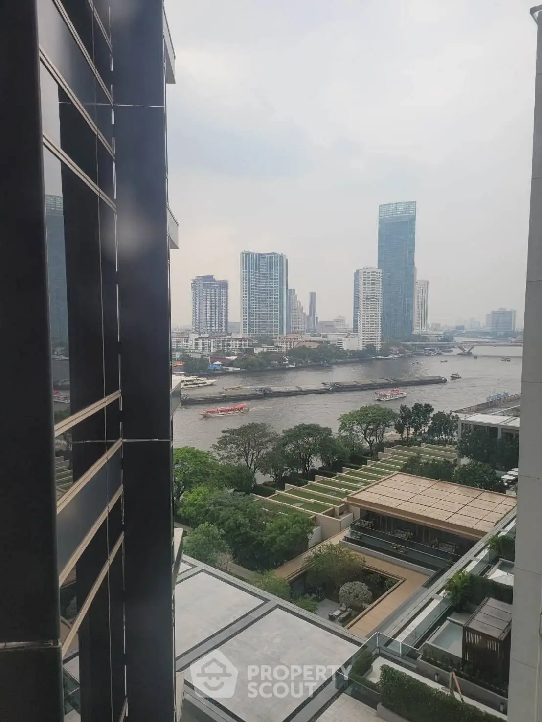 Stunning river view from high-rise building with lush greenery and modern architecture.