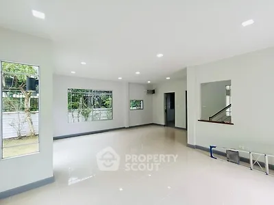Spacious empty living room with large windows and garden view
