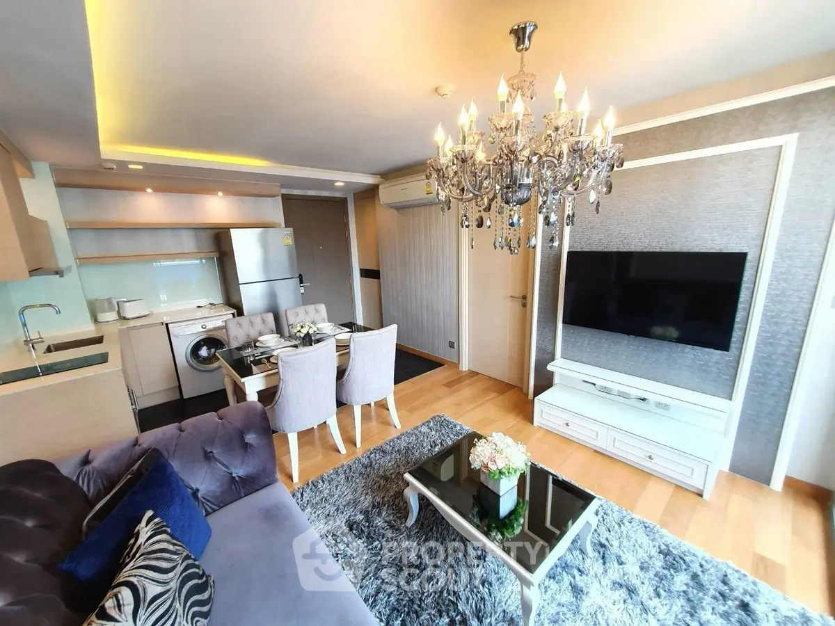 Luxurious living room with elegant chandelier and modern kitchen in open layout apartment