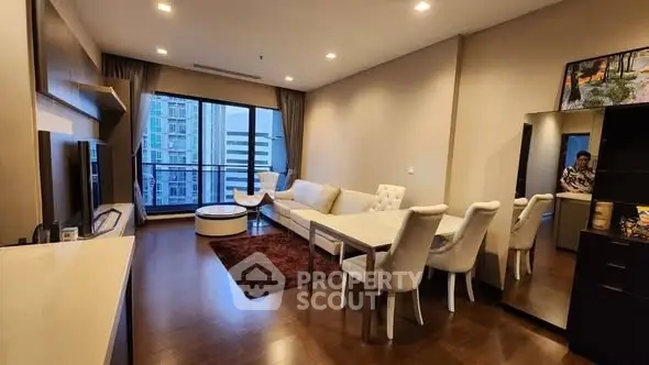 Spacious modern living room with elegant dining area and city view balcony.