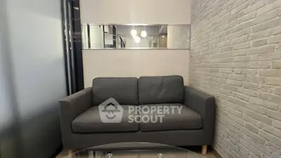 Cozy modern living room with stylish gray sofa and brick accent wall