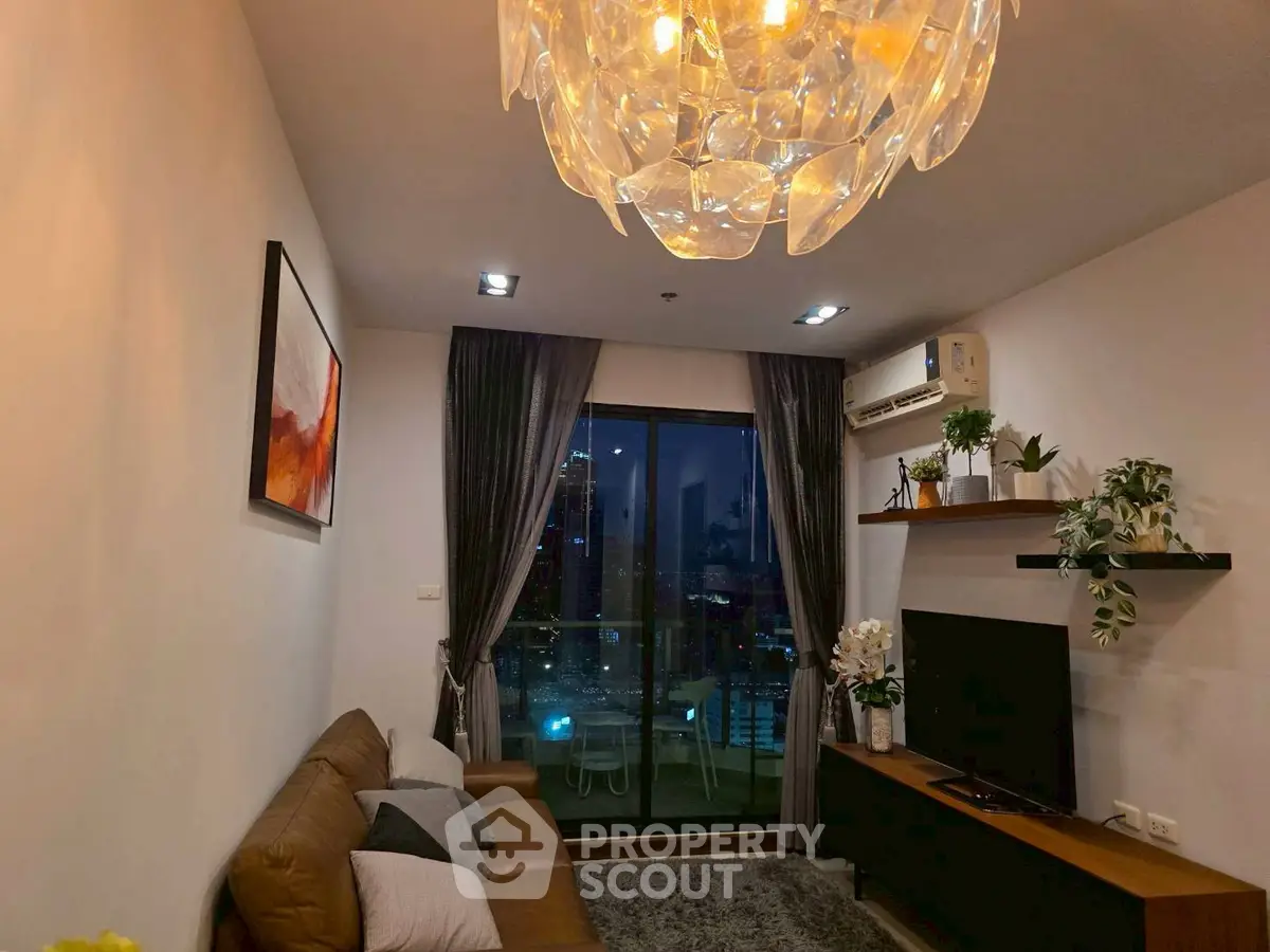 Modern living room with elegant chandelier and city view balcony