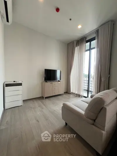 Modern living room with sleek furniture and large window offering natural light