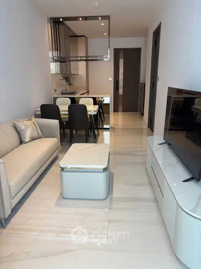 Modern living room with sleek furniture and open kitchen layout in a stylish apartment.