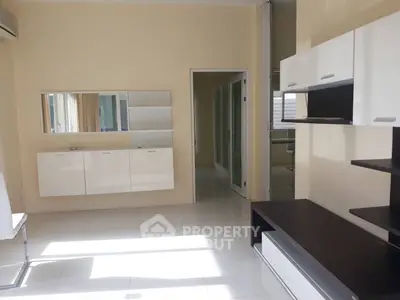 Modern living room with sleek white cabinets and ample natural light