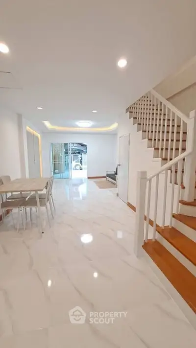 Spacious modern living area with elegant staircase and dining space