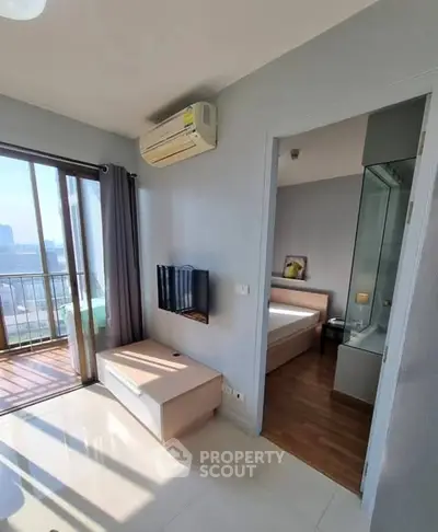 Modern apartment with balcony, bedroom, and air conditioning in a bright, sunlit space.