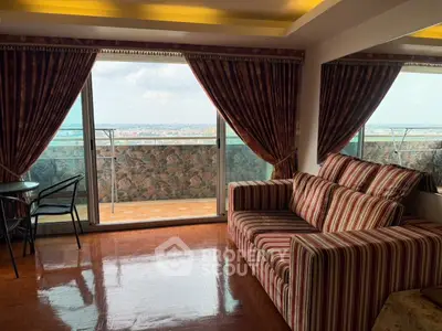 Spacious living room with striped sofa and large balcony offering stunning city views.