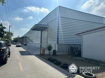 Modern industrial warehouse exterior with metal siding and spacious driveway