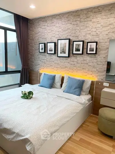 Modern bedroom with stylish decor and large window offering natural light.