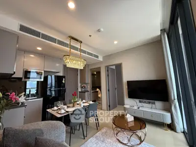 Luxurious modern living room with open kitchen and elegant dining area, featuring chic decor and ample natural light.