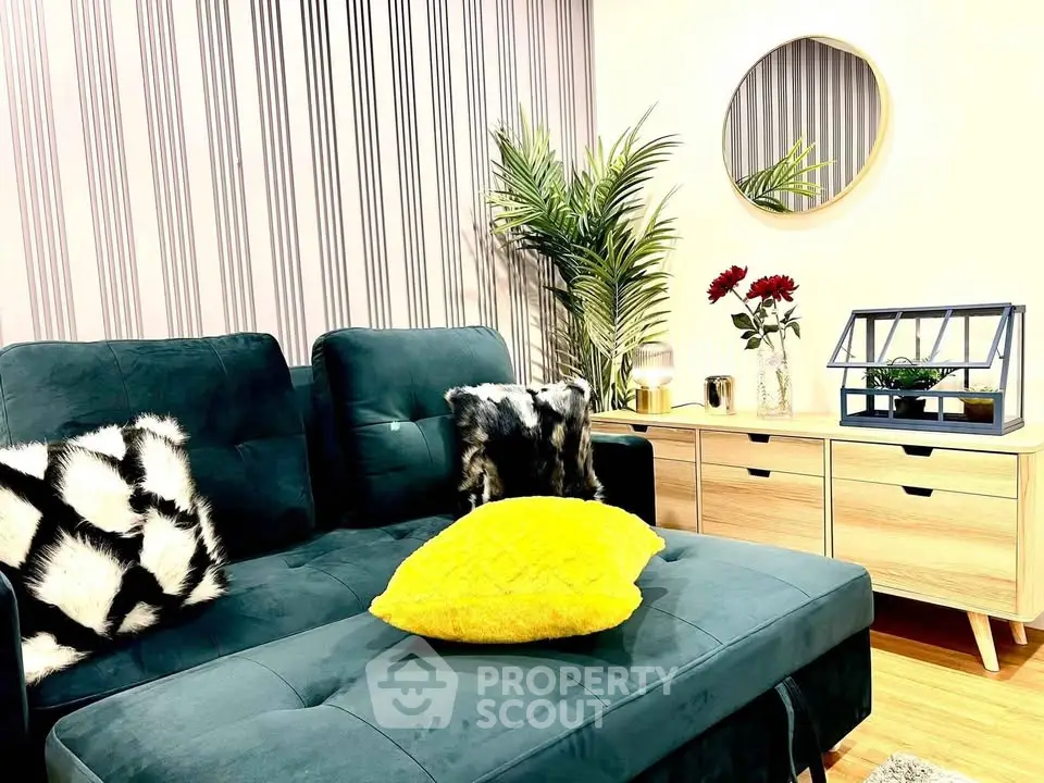 Stylish living room with modern decor, featuring a plush green sofa, chic mirror, and elegant sideboard.