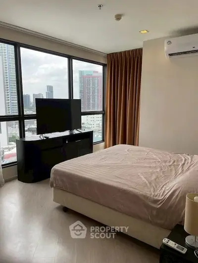 Spacious bedroom with city view and modern amenities in high-rise apartment