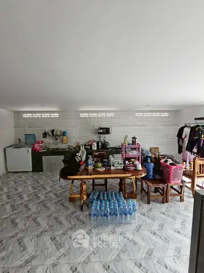 Spacious kitchen with tiled floor and ample storage, featuring modern appliances and dining area.