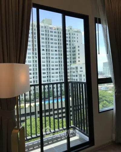 Modern apartment balcony with stunning city view and lush greenery