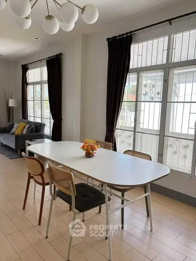 Spacious living room with elegant dining area and large windows, perfect for family gatherings.