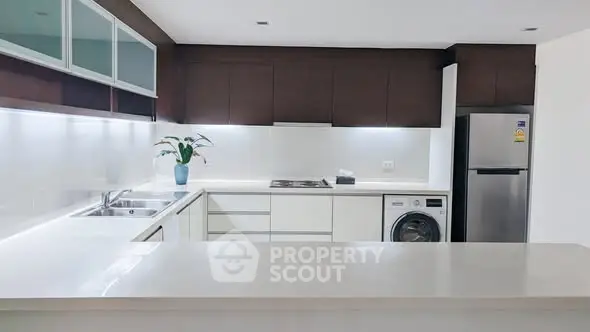 Modern kitchen with sleek white countertops and stainless steel appliances