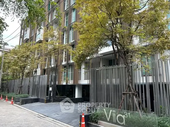 Modern apartment building exterior with lush trees and sleek design in urban setting.