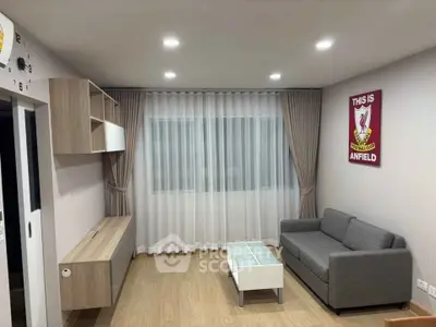 Modern living room with sleek furniture and stylish decor, featuring a cozy gray sofa and elegant curtains.