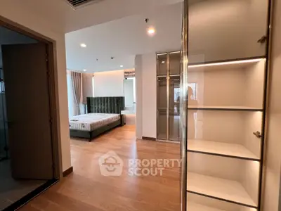 Spacious bedroom with elegant wooden flooring and modern furnishings in a luxurious apartment.