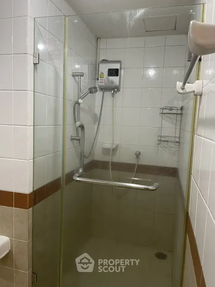 Compact bathroom shower with glass door and modern fixtures