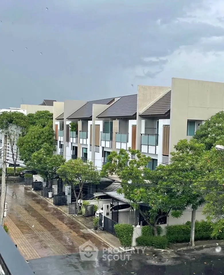 Modern townhouse complex with lush greenery and sleek design, perfect for urban living.