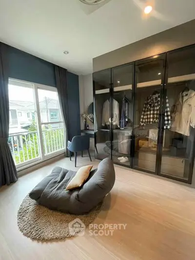 Stylish modern bedroom with glass wardrobe and cozy seating area