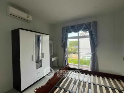 Spacious bedroom with large window and modern furniture